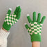Flat lay checkerboard knitted touch screen gloves with contrasting squares; cozy for cold-weather errands.