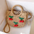 Front view of rattan straw bag with red cherry appliques and polka dot lining, great for everyday.