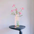 Close-up of Color Refracted Ripple Vase with flowers on a table.
