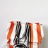 Side profile of the orange and black striped canvas tote bag, highlighting its large capacity.