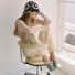 Model wearing black Floral Crochet Hat. Intricate white floral patterns offer a high-contrast modern look.