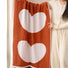 Model holding a red cotton bath towel with large heart pattern.