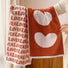 Model holding two face towels with Lover text and large heart patterns separately.
