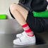 Red and white striped Lantern Colored Socks made of cotton-acrylic blend, worn with white sneakers.