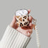 Model Hands holding a Leopard Print AirPods Case Cover with pearl string, ideal for gifting and everyday carry.