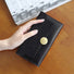 Model holding Long Wallet With Nubuck Leather Flap in black, great for daily carry and travel.