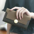Model holding Long Wallet With Nubuck Leather Flap in green, easy for everyday use and errands.