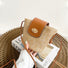 Model holding a middle size of Mini raffia straw bucket crossbody bag, showcasing the texture detail.