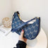 Model carrying a blue Monogram Crescent Bag handheld, easy for commuting and weekends.
