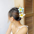 Model wearing two colors of Plumeria Hair Claws, one blue and one yellow.