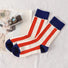 Angled view of Red and white striped crew socks with navy blue cuffs, heels, and toes.