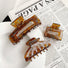 Set of three retro brown tortoiseshell acrylic hair claws in varying sizes and shapes.