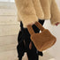 Model carrying a Sherpa Bucket Handbag in brown, great for everyday carry and travel.