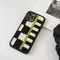 Sherpa Green Stripe case resting on a white surface next to an aesthetic magazine.