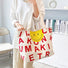 Model carring a Smileface Canvas Tote Bag in red, great for everyday carry and travel.