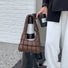 Model carrying a brown Soft Leather Puffer Shoulder Bag handheld, ideal for city walks and gifting.