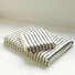 A set of striped face towel and bath towel, stacked together.