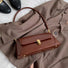 Brown vintage baguette shoulder bag made of glossy PU leather with gold hardware.