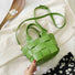 Angled view of Woven Leather Mini Basket Bag in fresh green, easy for commuting and weekends.