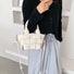 Model carrying a white Woven Leather Mini Basket Bag handheld, ideal for city walks and gifting.