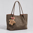 Pink Tilted Sunglasses Bear Bag Charm hanging on a suede bag.