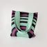 Folded view of Arc Line Knitted Bag in green and purple, easy for commuting and weekends.