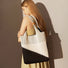 Artistic cream and black geometric pattern knitted tote bag made of soft polyester for gallery openings.