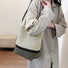 Model styling the cream dotted artistic pattern bucket bag with a neutral outfit.