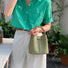 A model carrying the bamboo handle bucket bag in green, showcasing its elegant aesthetic for daily wear.