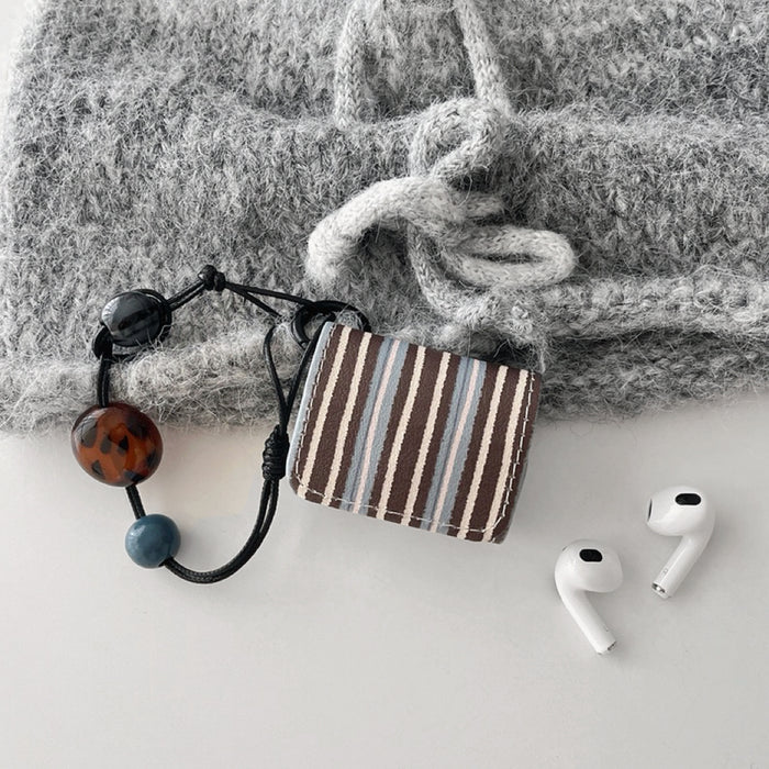 Front view of Beaded Melody Wrap AirPods case in brown, blue, and white stripes with a beaded strap.
