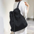 Rear view of the black 2-way bag used as a backpack, demonstrating the comfortable shoulder straps and drawstring detail.