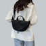 Back view of the black crinkle crossbody bag worn by a model, showing the wide strap fit.