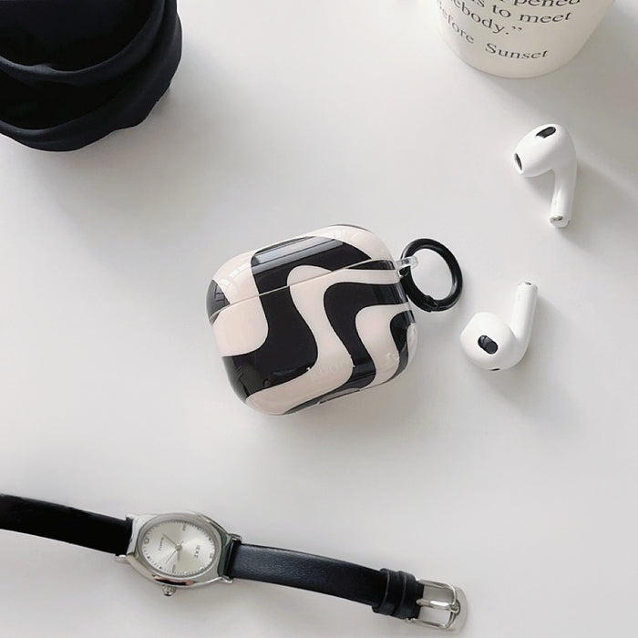 Front view of Black and white wavy silicone AirPods case cover with a black keyring, next to white AirPods.