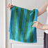 Model holding a Bold Color Striped Face Towel in blue-green, great for daily use.