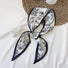 Folded view of Botanical Pattern Silk Scarf in silver and black, easy for travel packing and gifting.