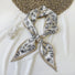 Front view of White polyester silk scarf with black botanical pattern and tan border, tied in a knot in khaki.