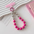 Angled view of Candy Bead Phone Charm in rose red, great for everyday styling and gifting.