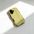 Close-up angled view of the yellow and white candy-striped wavy phone case under sunlight.
