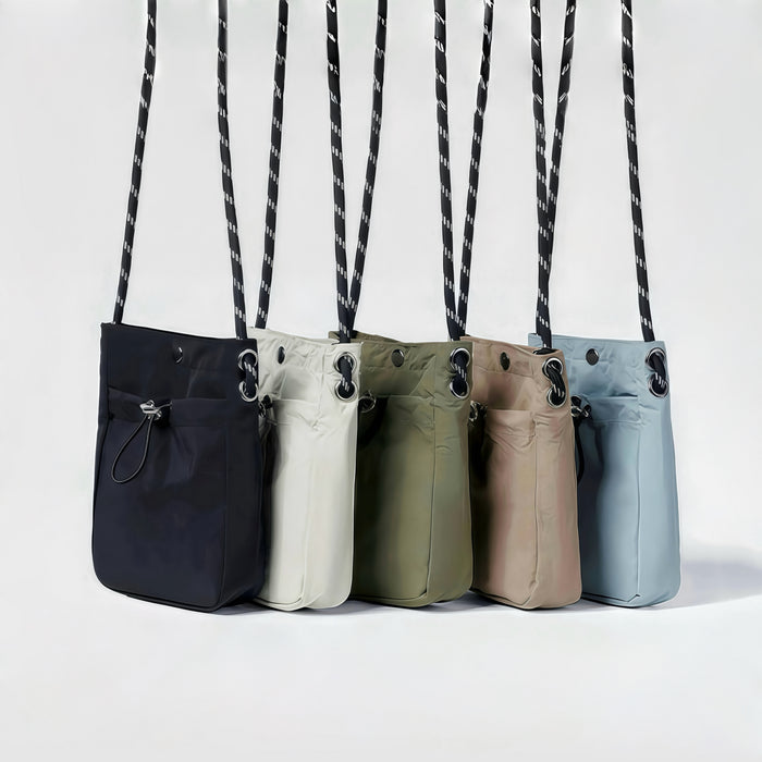 Five polyester Casual Lite Mini Bags in black, cream, olive, tan, and light blue, with drawstring pockets and adjustable straps.