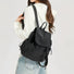 Model carrying a  black Check Mate Mini Backpack on her shoulder, easy for commuting and weekends.