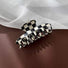 Folded view of checkerboard hair claw in cross shape, great for everyday styling and gifting.