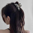 Model wearing checkerboard hair claw in curve shape, great for everyday styling and gifting; for office.