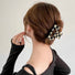 Model wearing checkerboard hair claw in rectangle shape, ideal for quick updos and ponytails.