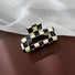 Angled view of checkerboard hair claw in rectangle shape, great for everyday styling and gifting.