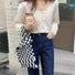 Model wearing a classic black and white checkered woven tote bag.