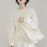 Model carrying a white bag as crossbody, great for daily carry and travel.