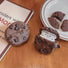 Close-up of two Chocolate Cookies AirPods case covers on the table, ideal for gifting and everyday use.