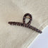 Flat lay of dark brown Leopard Print Hair Claw in one-word style, great for everyday styling and gifting.