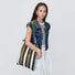 Model carrying a brown and green striped polyester bag on her shoulder, easy for commuting and weekends.