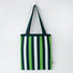 Flat lay of Chromatic Stripe Knitted Bag in white and green, great for everyday carry and travel.